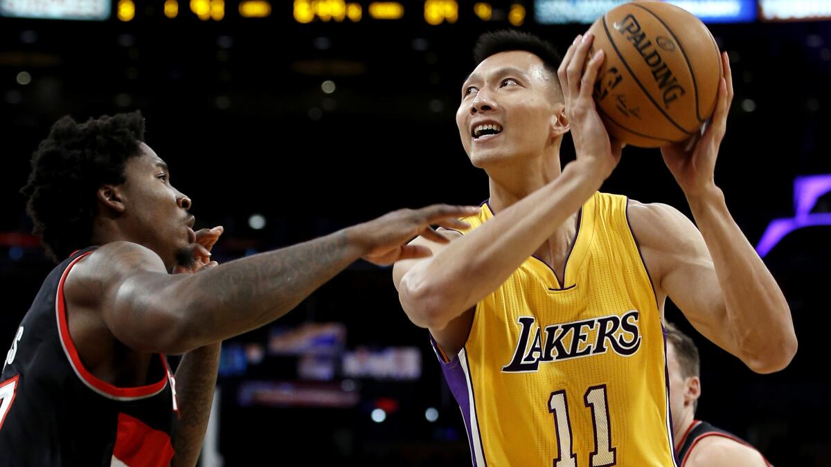 Lakers forward-center Yi Jianlian tries to score against Portland Trail Blazers power forward Ed Davis during a preseason game on Oct. 11.