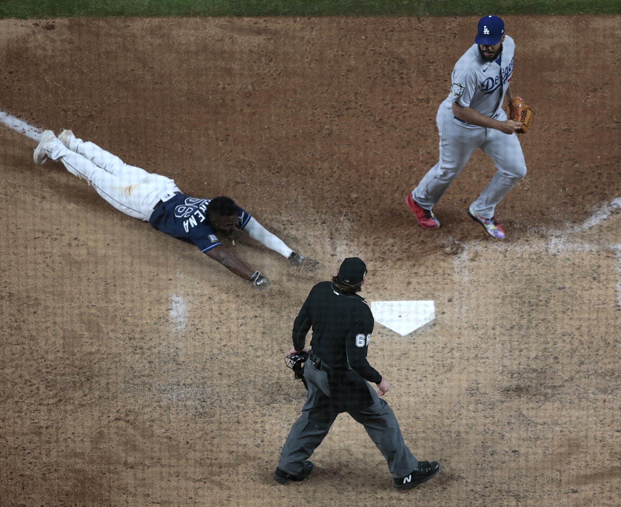 Randy Arozarena slides into home to score the winning run of an 8-7 victory over the Dodgers.