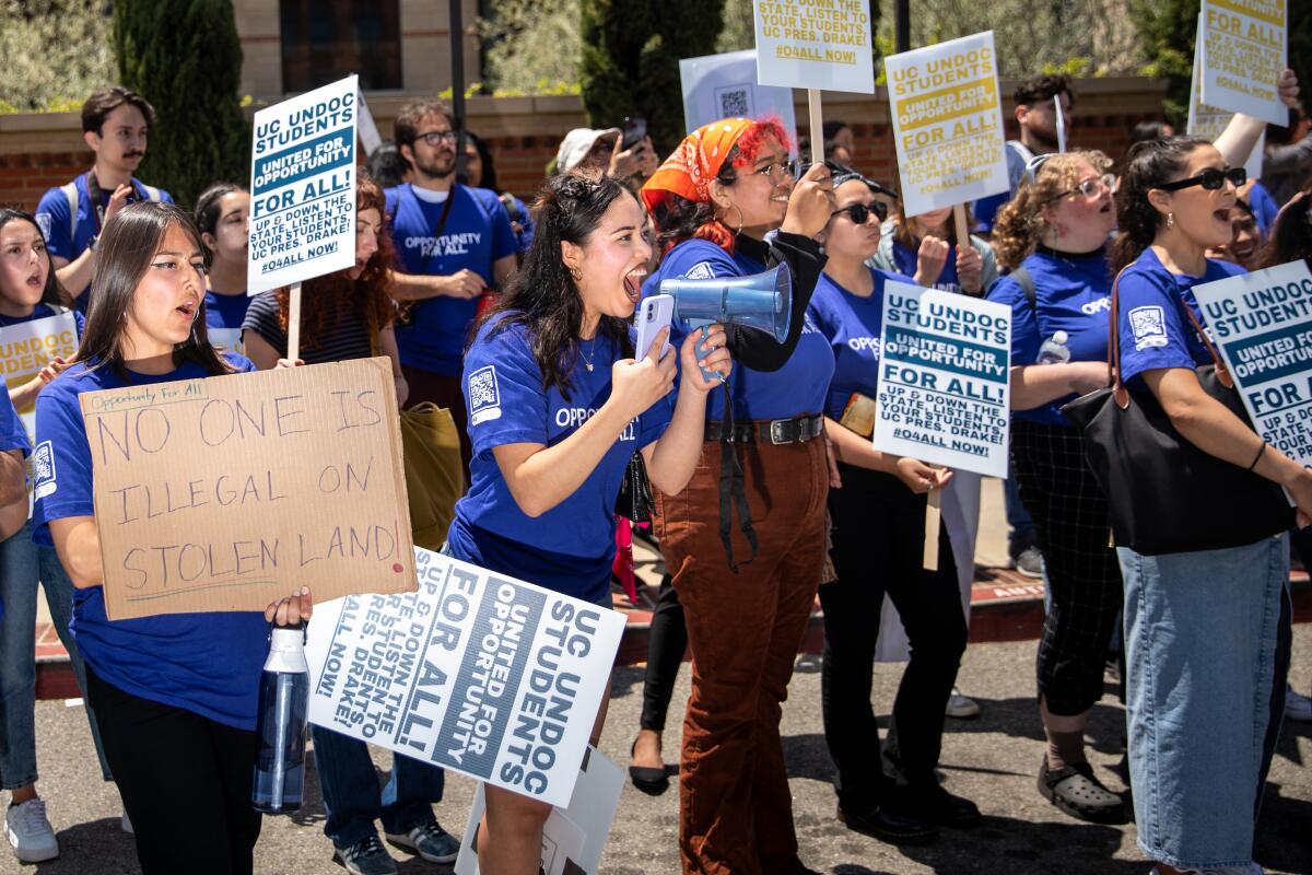 UC students wearing blue T-shirts gather for a campus demonstration.