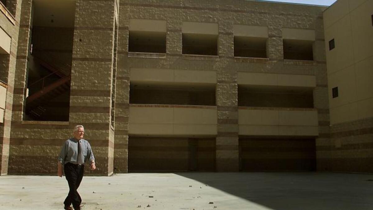 Then-L.A. schools Supt. Roy Romer walks across the grounds of the unfinished Belmont Learning Complex in 2002.