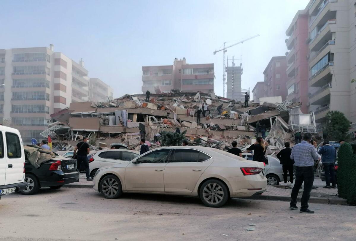 People work on a collapsed building in Izmir, Turkey, after a strong earthquake.