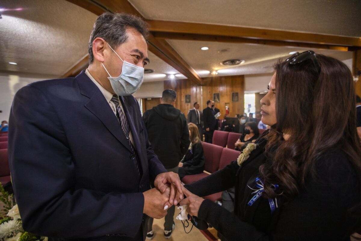 Curtis Hsing greets Evelyn Rivera Molina, right, Tom Rivera's daughter.