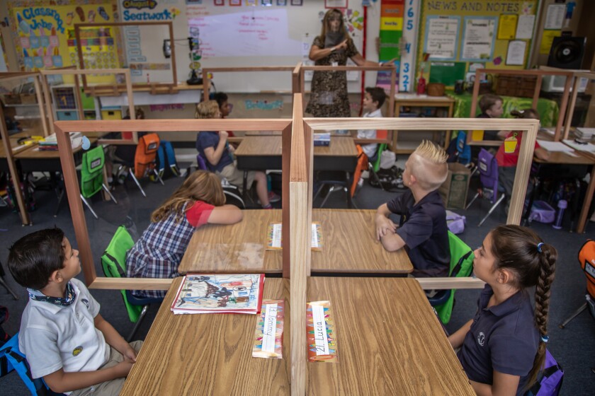Plexiglass desk dividers separated maskless students at Christian Unified East elementary school in El Cajon. 