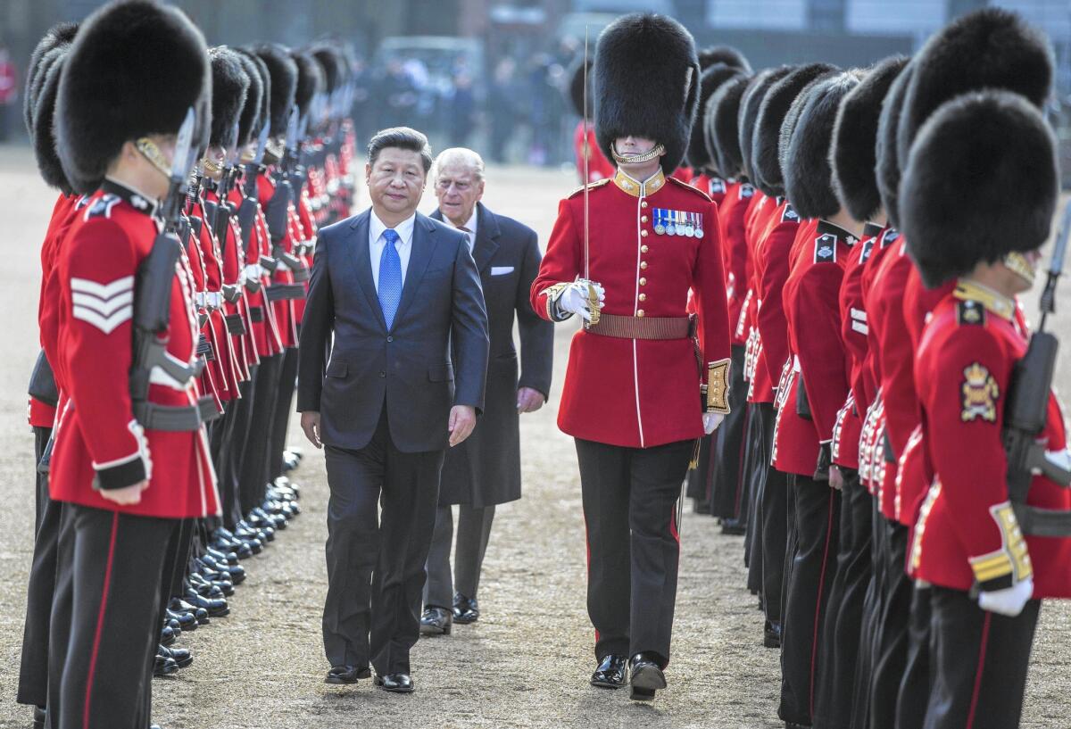 Chinese President Xi Jinping and Britain’s Prince Philip inspect an honor guard in London. "It is fair to say that China and the UK are increasingly interdependent and becoming a community of shared interests," Xi said later.