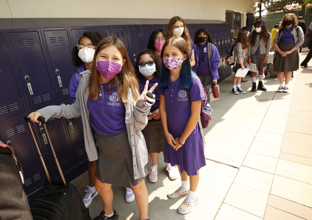London Braga-Stevens flashes the peace sign as she waits with sixth grade classmates to enter their classroom