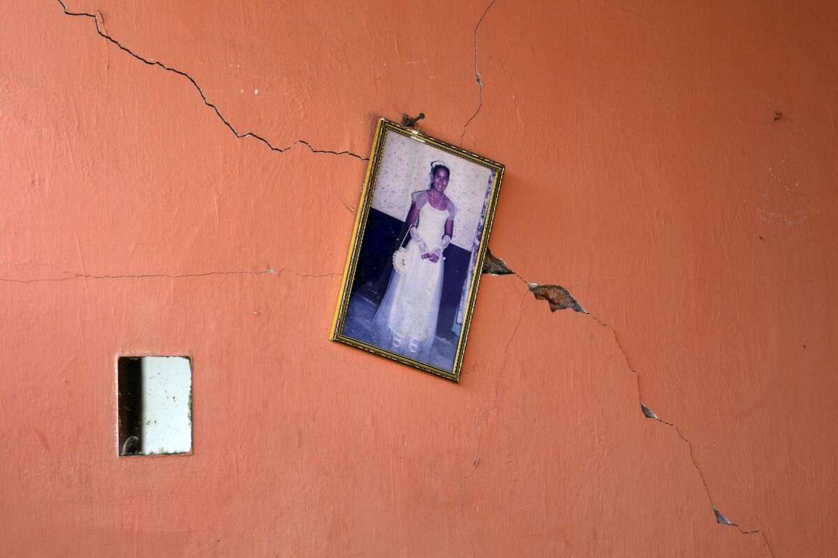 A portrait of a teenager hangs on a earthquake-damaged wall in Canoas, Ecuador.