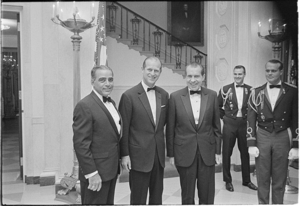 In this Nov. 4, 1969, image provided by The Richard Nixon Library & Museum, President Richard Nixon, center, stands with Prince Philip, second from left, prior to a black tie state dinner. (The Richard Nixon Library & Museum via AP)