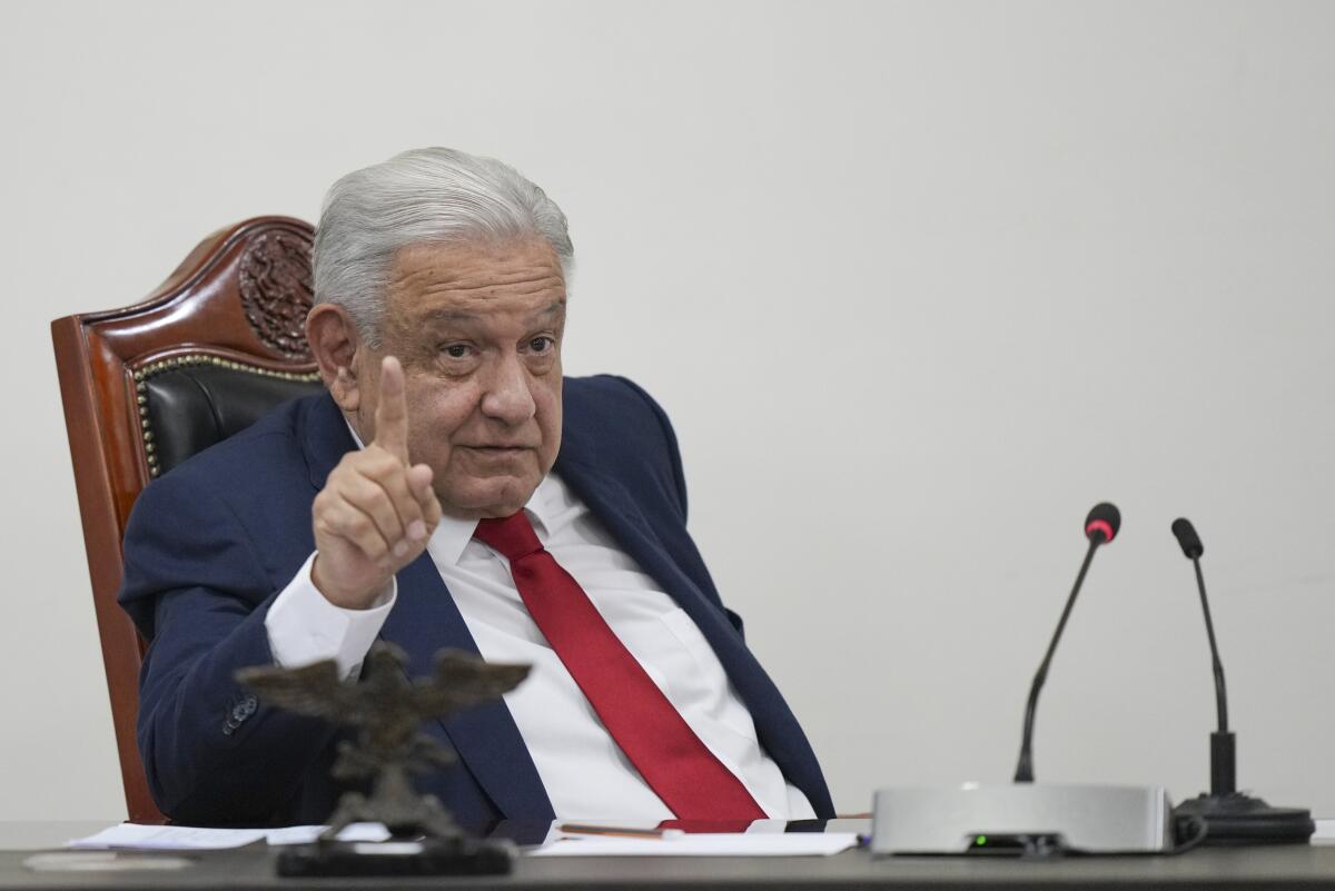 Andrés Manuel López Obrador leans back in a chair, raises his eyebrows and holds up his index finger.  