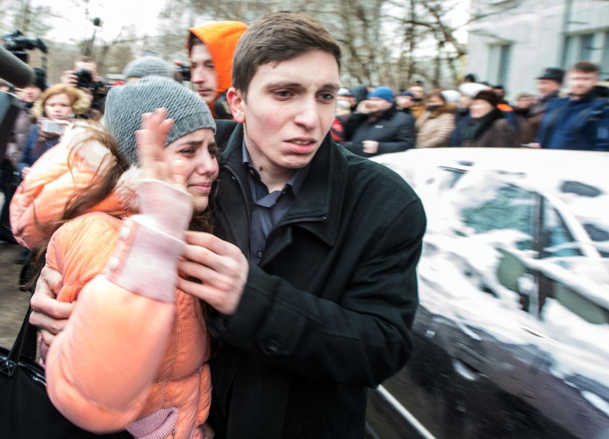 A girl leaves the Moscow school where authorities said a student fatally shot a teacher and a police officer.