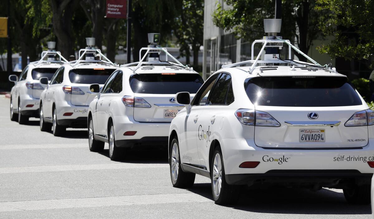 A row of Google self-driving Lexus cars line up at an event outside the Computer History Museum in Mountain View, Calif., in 2014.
