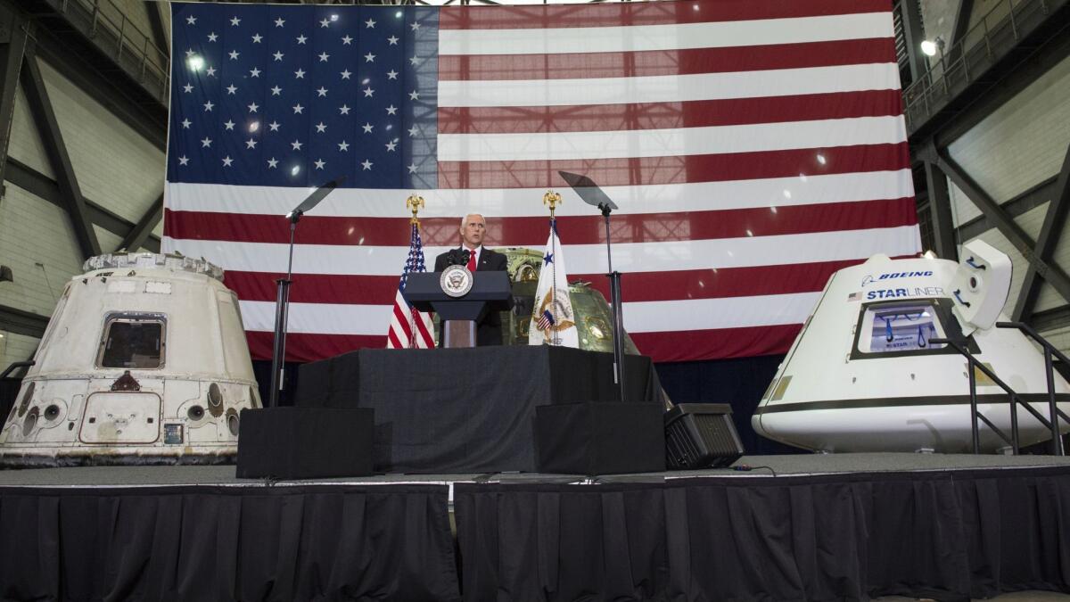 Vice President Mike Pence addresses NASA employees in front of, from left, the SpaceX Dragon, NASA's Orion, and Boeing's Starliner capsules in July 2017 at Kennedy Space Center in Florida.