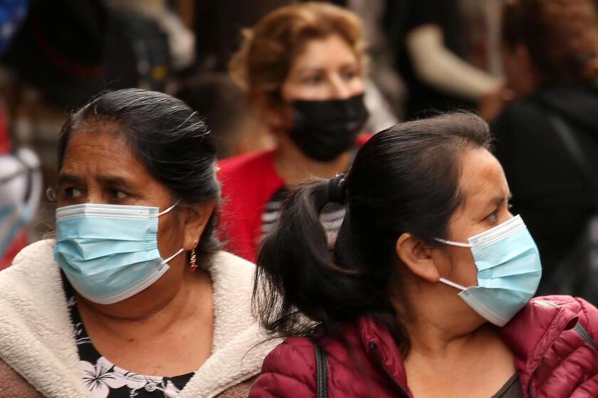 LOS ANGELES, CA - DECEMBER 6, 2022 - - Shoppers, some wearing masks, some not, make their way along Santee Alley in Los Angeles on December 6, 2022. Los Angeles County appears in the midst of another full-blown coronavirus surge, with cases rising by 75% over the last week. The spike - which partially captures but likely does not fully reflect exposures over the Thanksgiving holiday - is prompting increasingly urgent calls for residents to get up to date on their vaccines and consider taking other preventative steps to stymie viral transmission and severe illness. (Genaro Molina / Los Angeles Times)