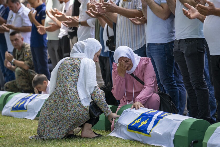 Unas mujeres lloran previo al funeral de unas víctimas recién identificadas 