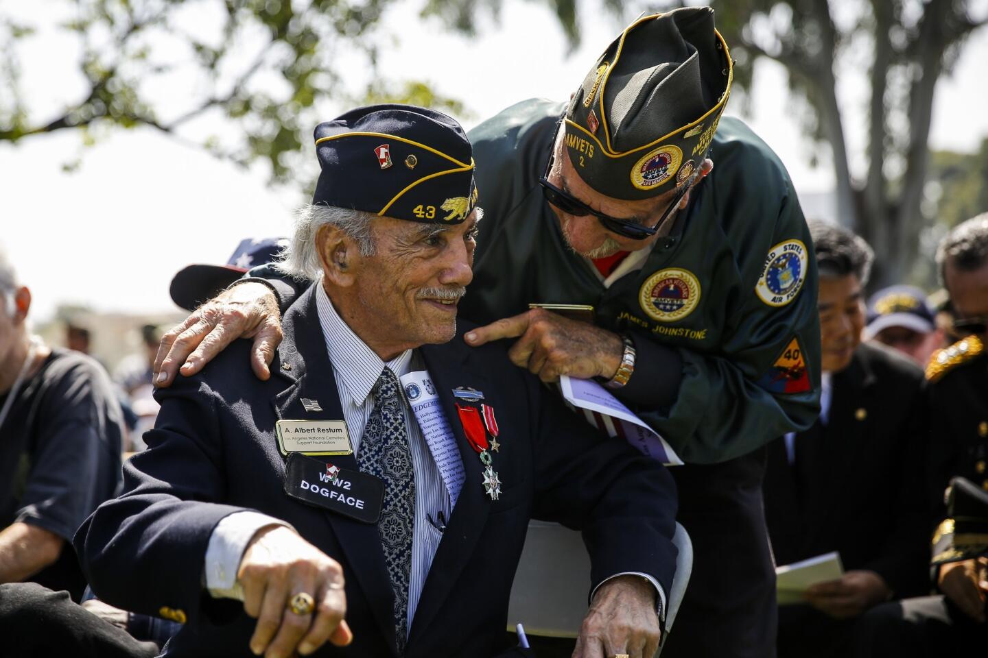 A. Albert Restum, 89, who served in the Army two years before joining the Air Force, left, talks with Air Force veteran James Johnstone, a member of the Amvets Honor Guard, before the start of a Memorial Day ceremony at Los Angeles National Cemetery.