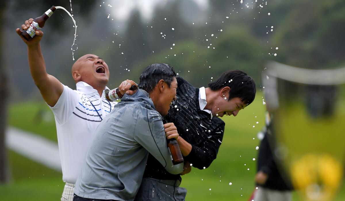 Jason Oh, left, and Noh Seung-Yul, right, celebrate with James Hahn after he won a three-man playoff at the Northern Trust Open on Sunday at Riviera Country Club.