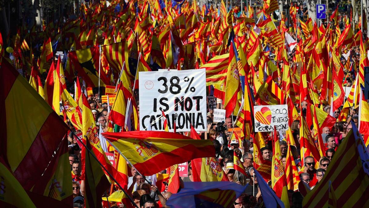 Protesters wave Spanish and Catalan Senyera flags during a pro-unity demonstration in Barcelona on Sunday. The sign reading "38% is not Catalonia" refers to turnout for the referendum on independence.