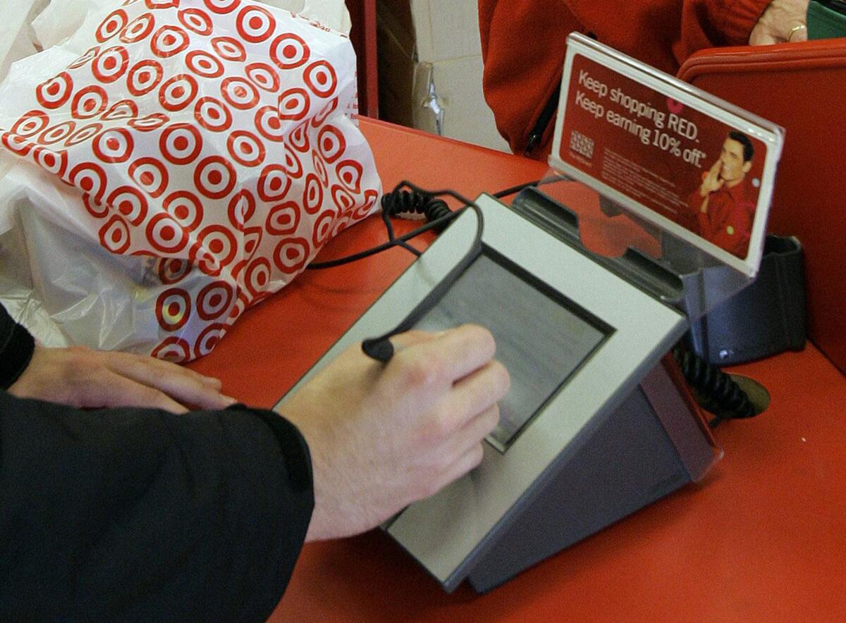 A customer signs for a credit card purchase at a Target store in Tallahassee, Fla., in 2008. Target says that about 40 million credit and debit card accounts customers may have been affected by a data breach that occurred at its U.S. stores between Nov. 27, 2013, and Dec. 15, 2013. The retailer, along with Neiman Marcus, will not appear at an Assembly hearing addressing the issue.