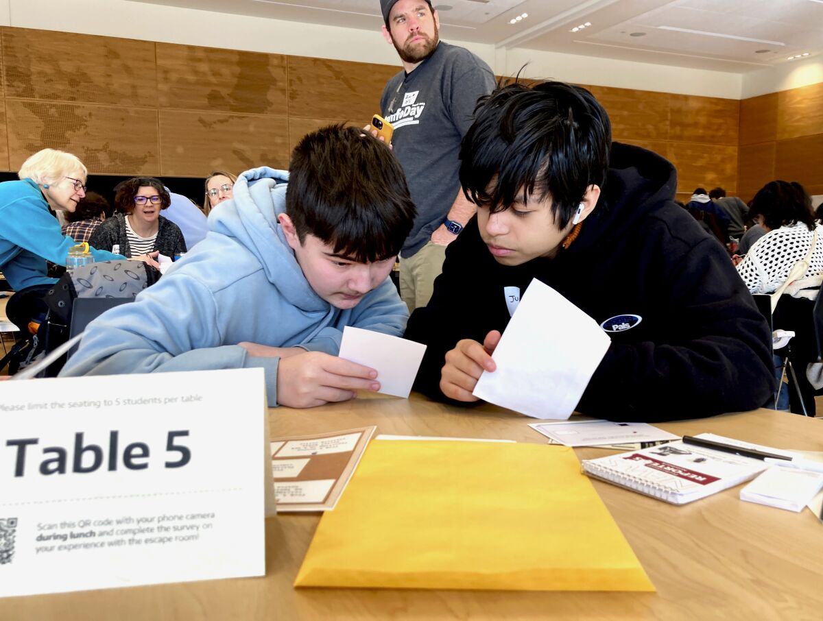 Meadowdale High School 9th grade students Juanangel Avila, right, and Legacy Marshall, left, work together to solve an exercise at MisinfoDay, an event hosted by the University of Washington to help high school students identify and avoid misinformation, Tuesday, March 14, 2023, in Seattle. Educators around the country are pushing for greater digital media literacy education. (AP Photo/Manuel Valdes)