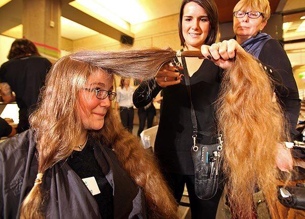 Katherine Svoboda, 20, watches as her hair is cut off by Sarah Davis, left, and Elizabeth Hartley of the Vidal Sassoon Academy for a "Locks of Love" event at the UCLA campus. More than 240 UCLA students, staff, alumni and friends got their hair cut. The hair will be donated to the nonprofit, which creates wigs for children who have lost their hair because of illness. The cuts were provided by student stylists from the Vidal Sassoon Academy in Santa Monica, and the event was hosted by the Alumni Scholars Club, a student group that is part of the UCLA Alumni Assn. Svoboda is a senior at Pierce College in the San Fernando Valley, and her father is a UCLA alumnus.