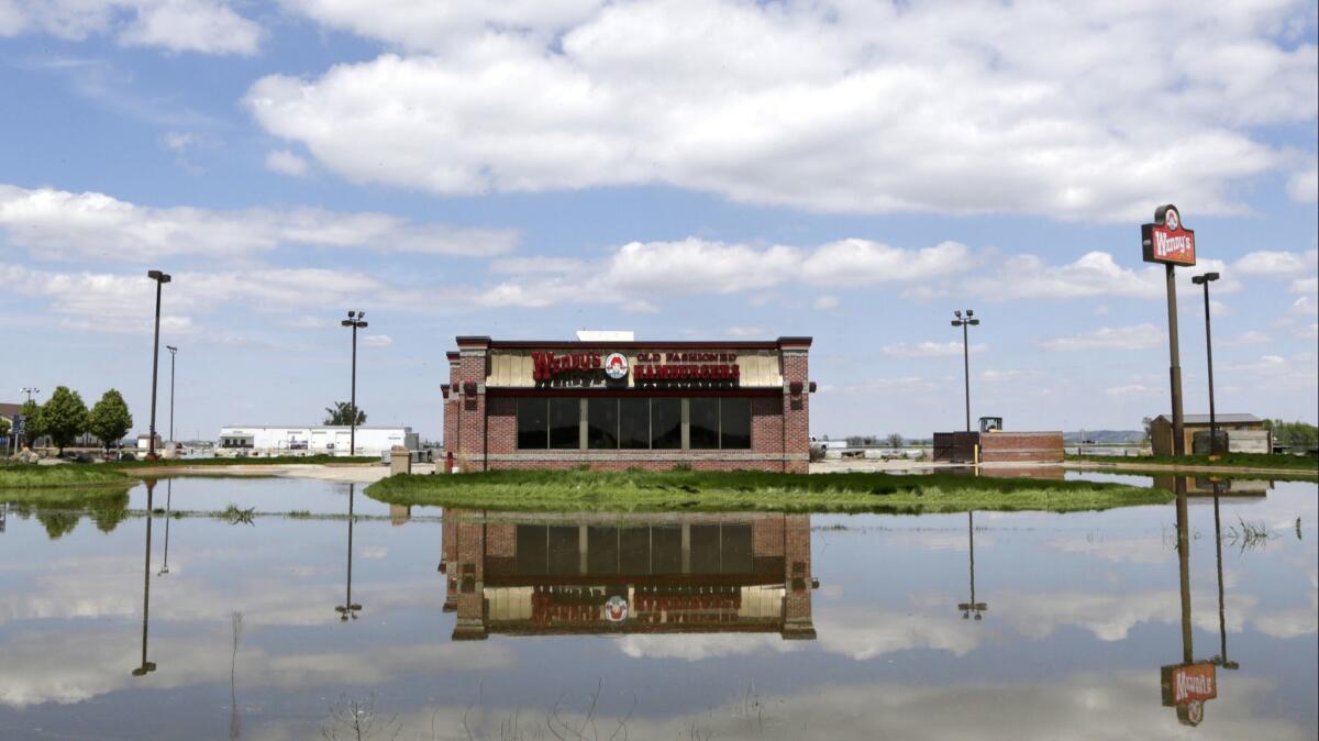 A Wendy’s outlet in Percival, Iowa, is reflected in floodwaters from the Missouri River in May.