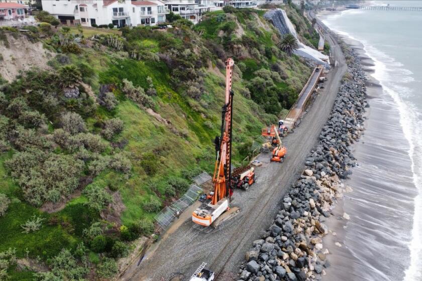 A crane was staged near the San Clemente landslide on Sunday in preparation for work on a barrier wall to begin Monday.