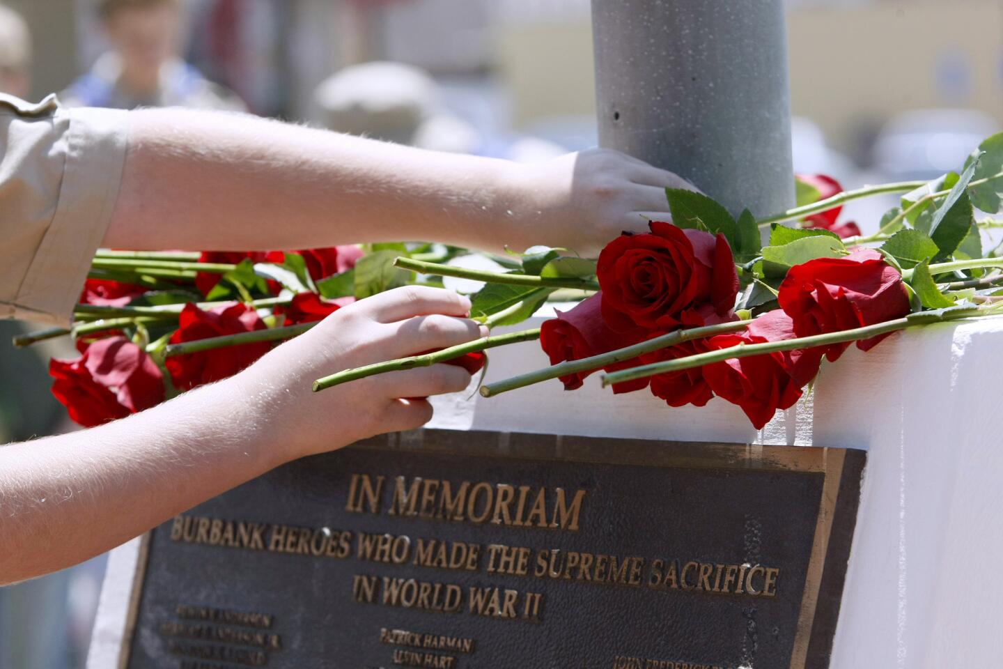 Boy Scouts place roses on memorial during the Ceremony of the Rose at the Memorial Day Ceremony at McCambridge Park War Memorial in Burbank on Monday, May 26, 2014.