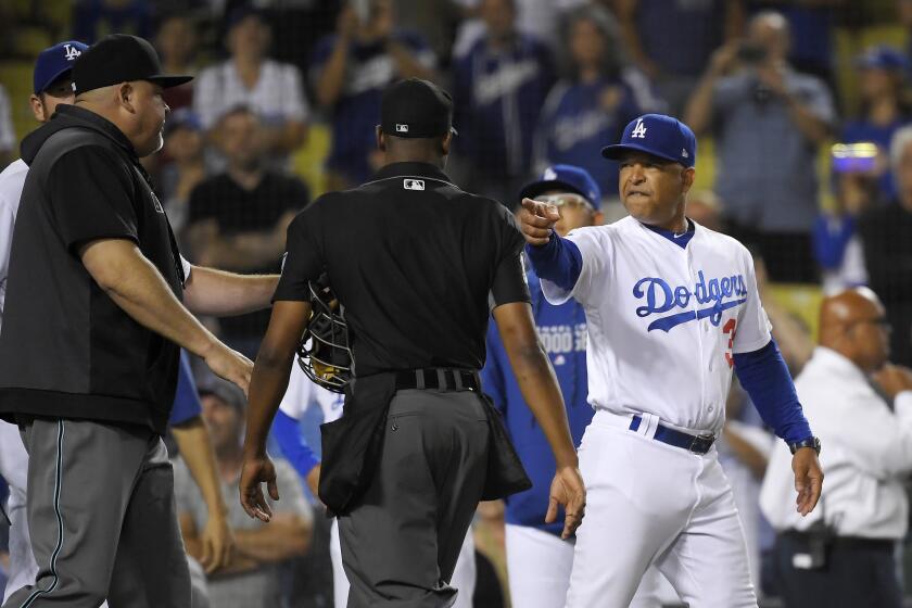 Los Angeles Dodgers manager Dave Roberts, right, gestures toward members of the Arizona Diamondbacks during a scuffle between the teams after the Diamondbacks defeated the Dodgers 3-2 during in a baseball game Friday, Aug. 9, 2019, in Los Angeles. (AP Photo/Mark J. Terrill)