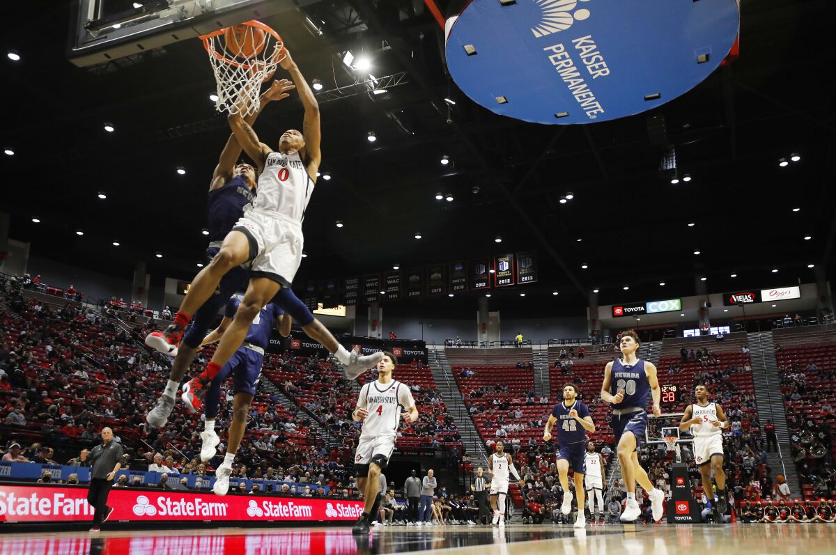 San Diego State's Keshad Johnson slams the ball and is fouled by Nevada's Desmond Cambridge Jr..