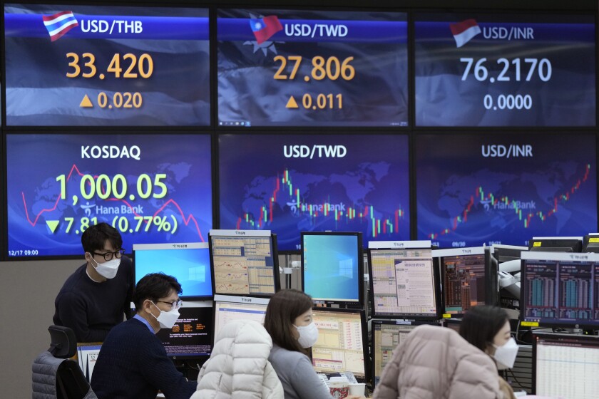 Currency traders watch monitors at the foreign exchange dealing room of the KEB Hana Bank headquarters in Seoul, South Korea, Friday, Dec. 17, 2021. Shares fell in Asia on Friday after technology companies led Wall Street benchmarks lower as investors weighed the implications of higher interest rates, surging coronavirus cases and tensions between Beijing and Washington. (AP Photo/Ahn Young-joon)