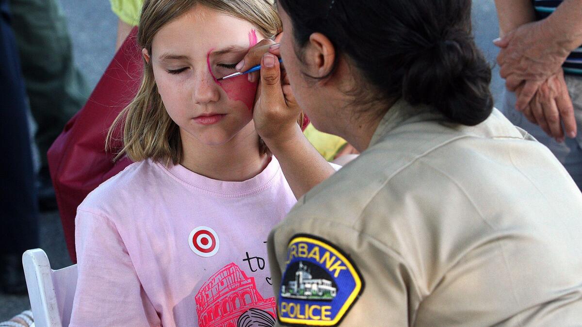 Burbank Police Cadet Kelly Bravo-Cuevar paints Katelynn Meline's face at Burbank's National Night Out along the Chandler Bikeway in August 2016.