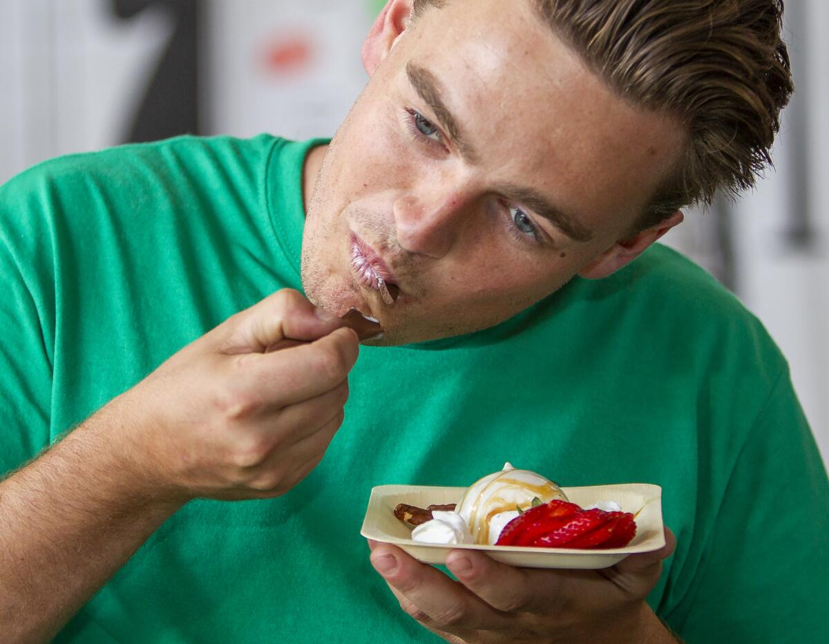 Colin Kokenge takes a bite of gelato using an edible spoon at the Orange County Fair on Friday.