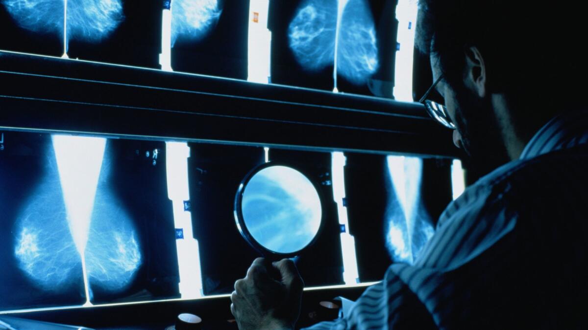 A radiographer studies mammograms. Health plans and some Medicaid programs are increasingly offering financial incentives to motivate patients to engage in preventive care.