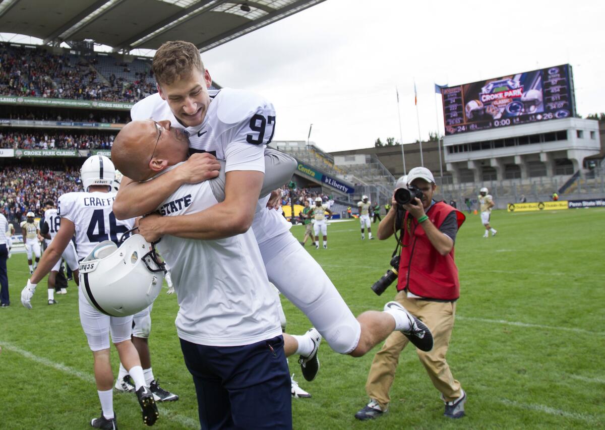 Penn State Coach James Franklin lifts place kicker Sam Ficken, who kicked the game-winning field goal as time expired Saturday in a 26-24 victory over Central Florida in Dublin, Ireland.