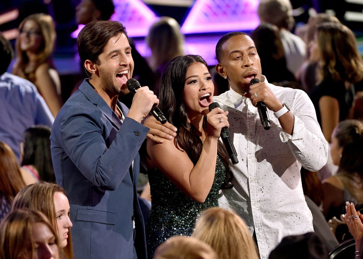 Co-hosts Josh Peck, left, Gina Rodriguez and Ludacris on stage during the Teen Choice Awards 2015 at the USC Galen Center.