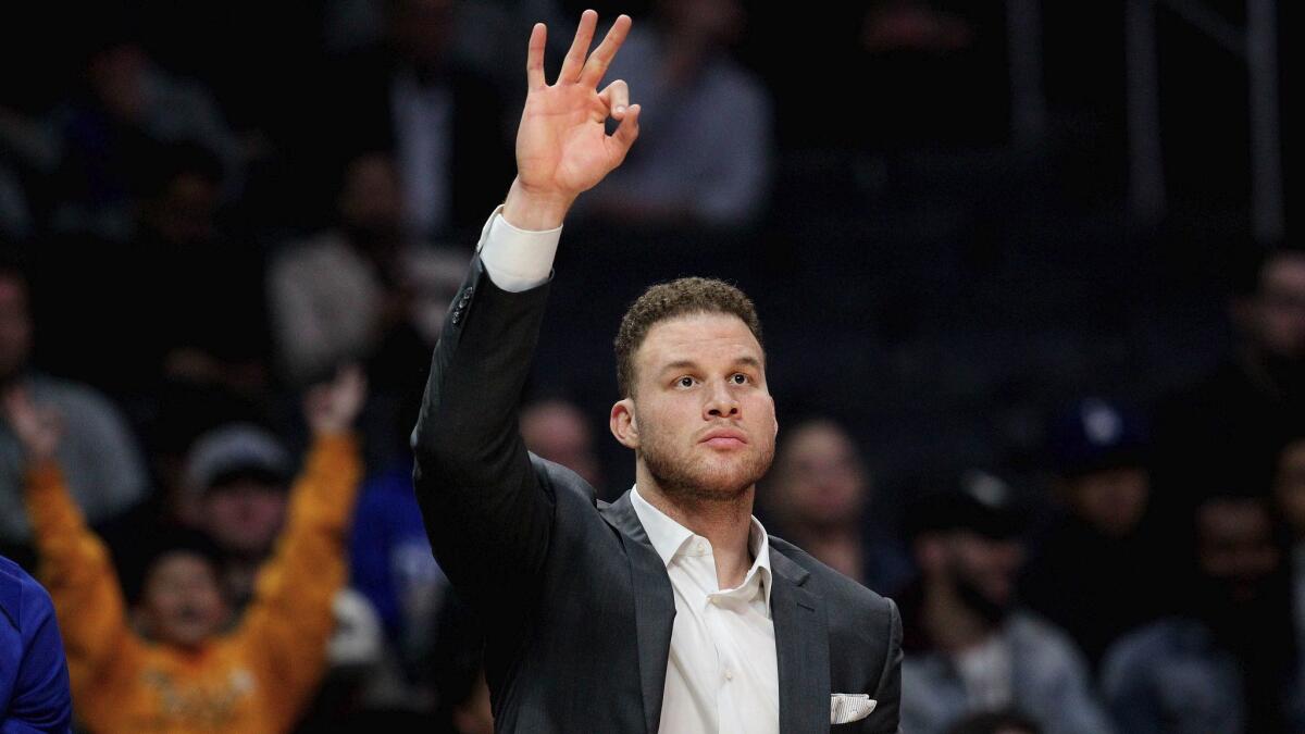 Injured Clippers forward Blake Griffin signals for a three-point basket during a Dec. 26 game against the Sacramento Kings at Staples Center.