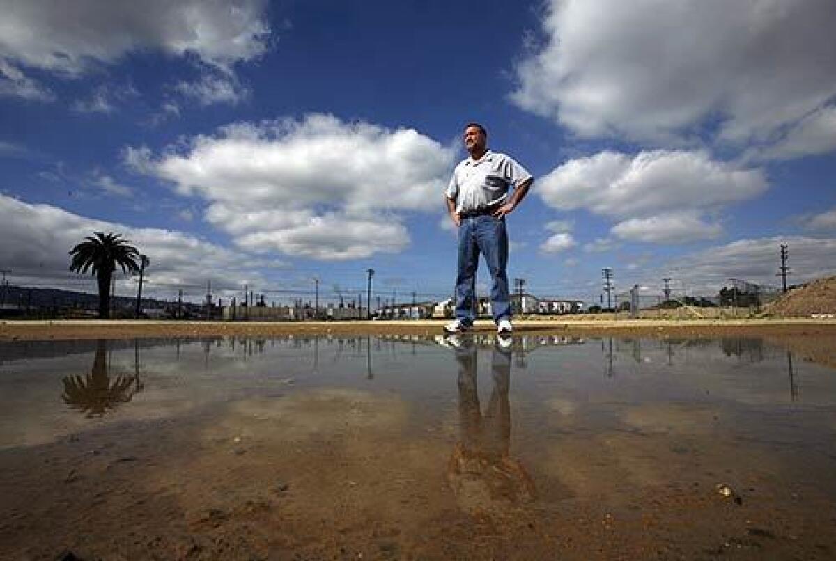 Ken Melendez, an advisor to the port community of Wilmington, stands on one of the empty lots that will be transformed into parkland buffer in a $57-million project. This is the biggest and most positive improvement in the history of Wilmington, said Melendez.