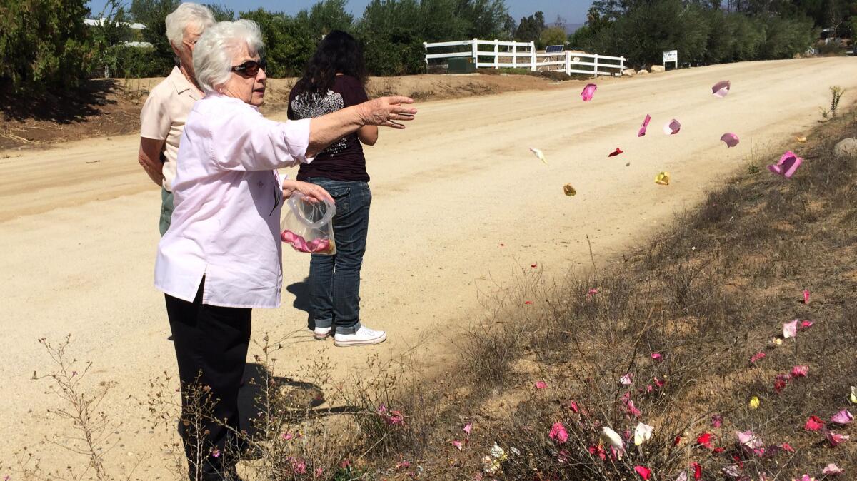 Clara Trevino scatters rose petals in front of the property where her disabled nephew, Miguel Ferreyra ,was found dead. "I just think about how they felt trying to get out and nobody was there to help them," Trevino said.