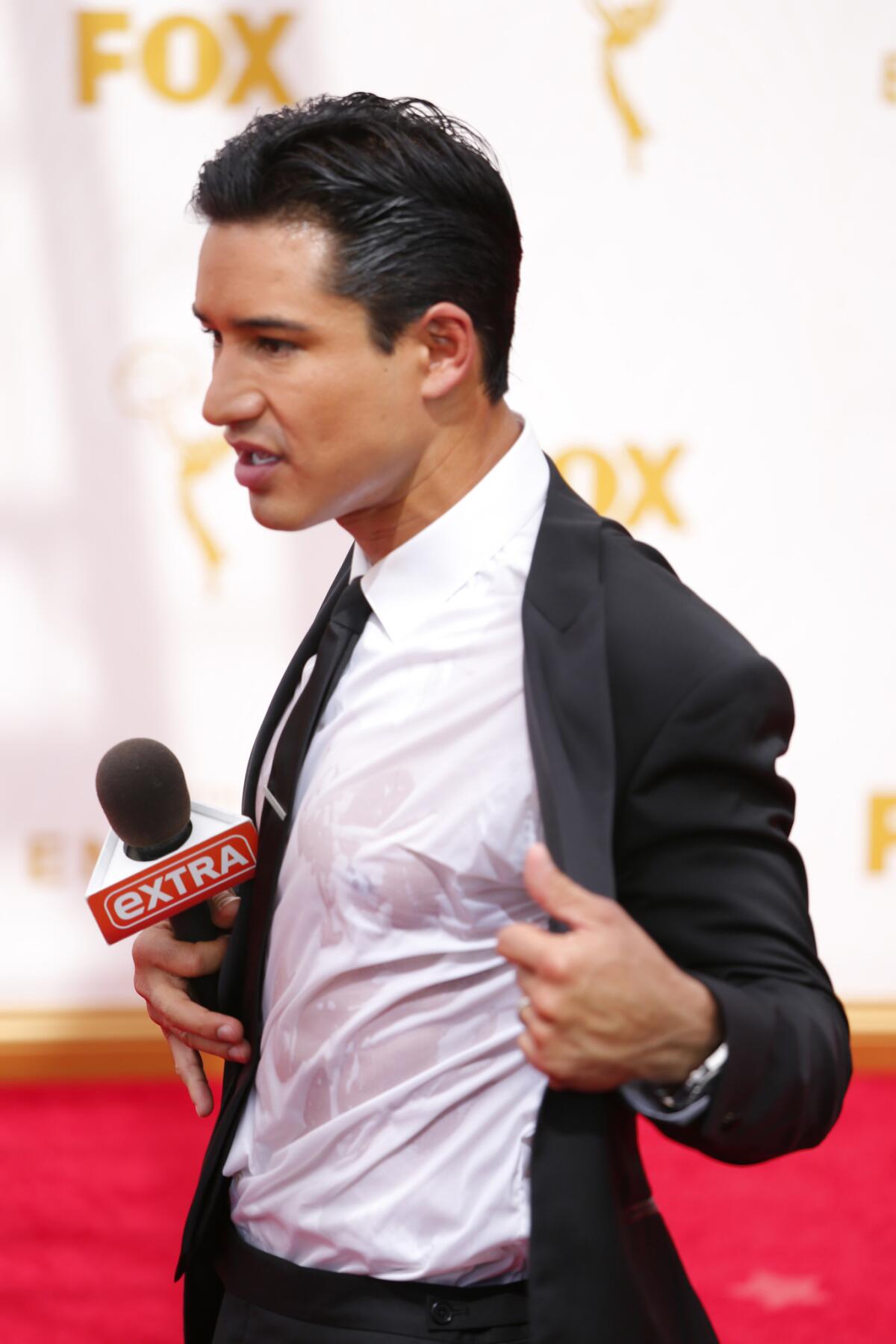 Mario Lopez shows off his drenched shirt on the red carpet prior to the 67h Annual Primetime Emmy Awards.