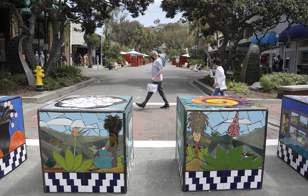 Public art squares embedded with tiles by Marlo Bartels adorn one of the entryways to the new Promenade on Forest.