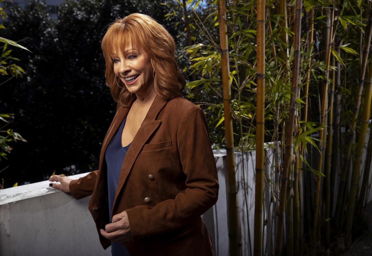 Country singer Reba McEntire smiles while standing.