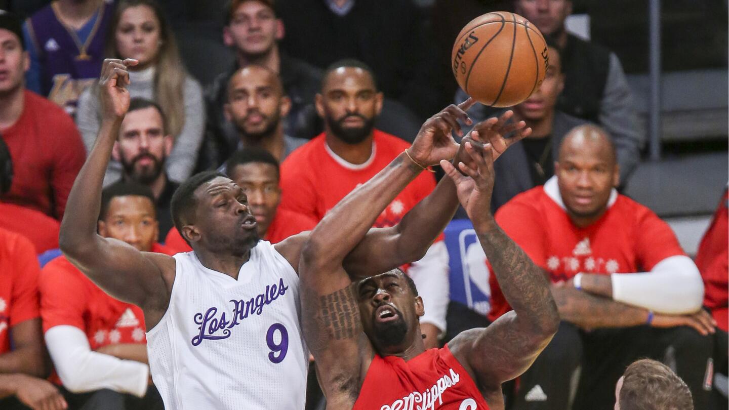 Clippers center DeAndre Jordan and Lakers forward Luol Deng fight for a ball during the first half.