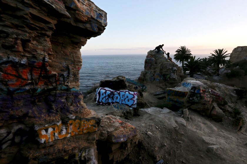 Two people climb on the remnants of house foundations at Sunken City, which overlooks the Pacific Ocean near Point Fermin.