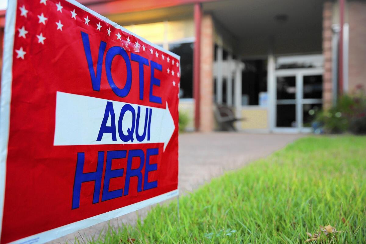 A bilingual sign points to a polling station in Austin, Texas, last year. Republicans in Texas and Florida have had success wooing Latinos, but that’s not the case elsewhere.