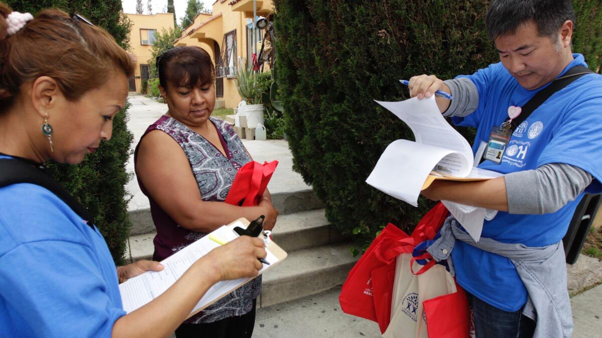 Volunteers Elizabeth Mateo, left, and Alex Chang interview Margarita Torrez as part of a survey of residents living near the former Exide battery-recycling plant.