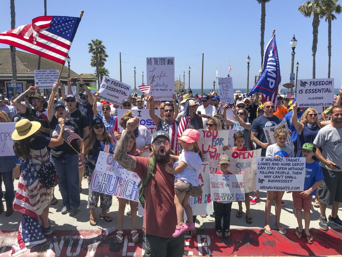 Protesters rally on May 1 in Huntington Beach over beach closures.
