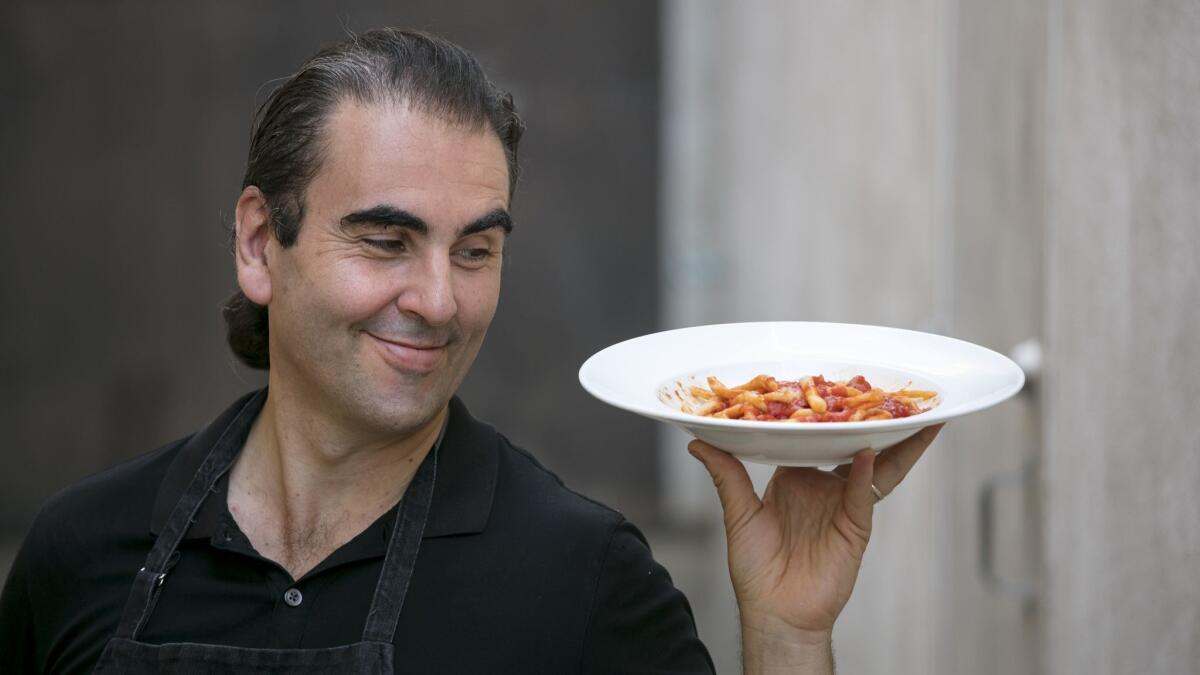 Bulgarini chef-owner Leo Bulgarini poses for a picture with a plate of his pici all'aglione.