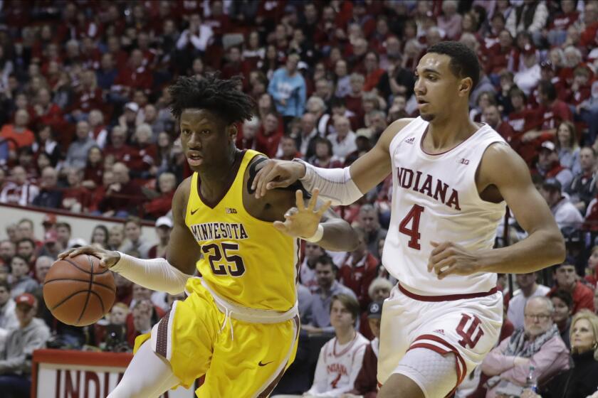 Minnesota's Daniel Oturu (25) goes to the basket against Indiana's Trayce Jackson-Davis (4) during the second half of an NCAA college basketball game, Wednesday, March 4, 2020, in Bloomington, Ind. Indiana defeated Minnesota 72-67. (AP Photo/Darron Cummings)