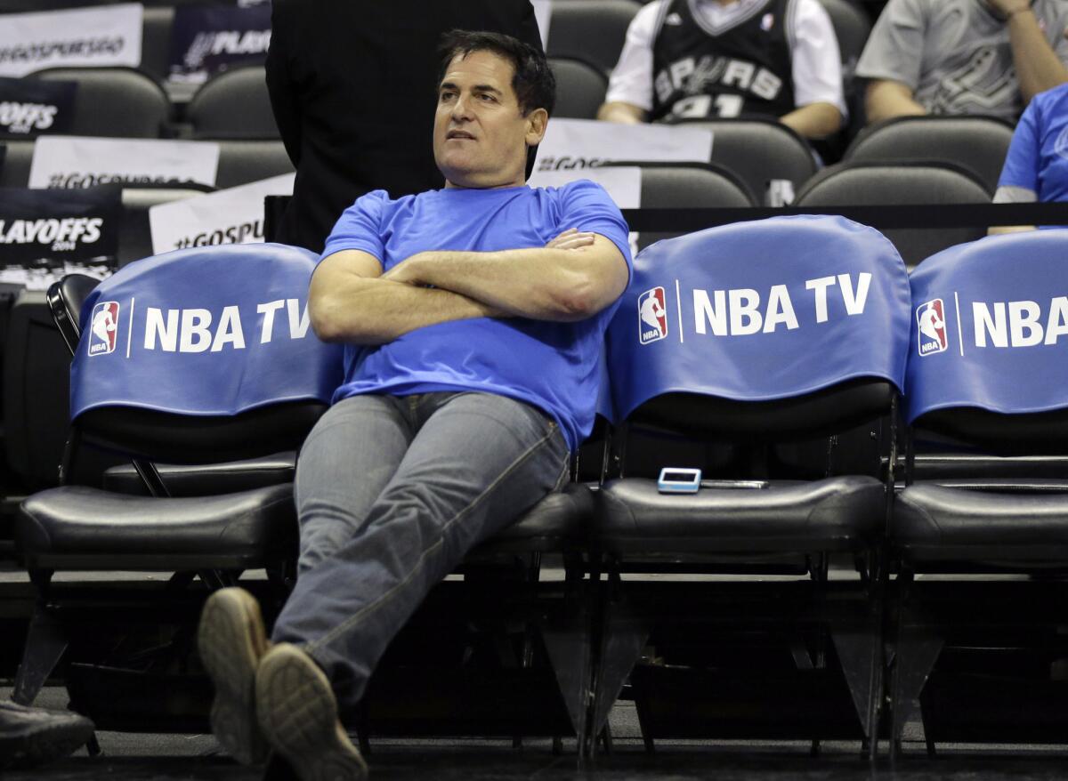 Dallas Mavericks owner Mark Cuban sits on the team's bench before Game 5 of a 2014 NBA playoff series against the San Antonio Spurs.