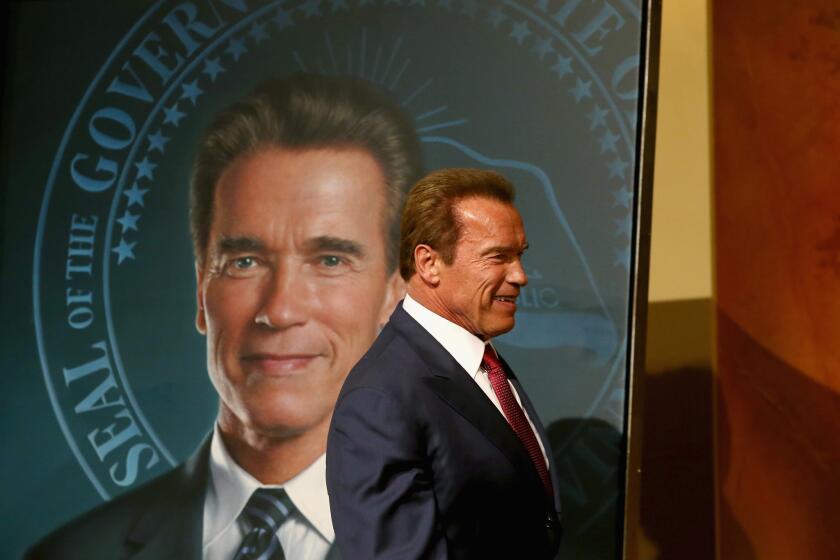 Former Calif. Gov. Arnold Schwarzenegger stands in front of his gubernatorial portrait at the unveiling in the Rotunda of the State Capitol in 2014.