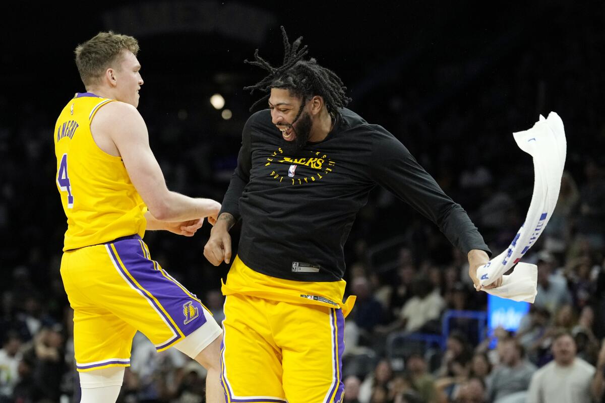 Lakers star Anthony Davis (right) celebrates with rookie guard Dalton Knecht after shooting a three-pointer against the Suns.